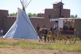 Horse and carriage riding towards teepee inside of Bent's Old Fort National Historic Site in Fowler, Colorado.