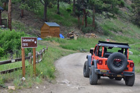 Jeep at the entrance sign to the Switzerland Trail in the Indian Peaks Wilderness Area of Colorado.