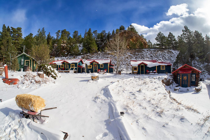 Log Cabins blanketed in snow during the winter at Raymond Store Cabins between Lyons and Allenspark, Colorado.