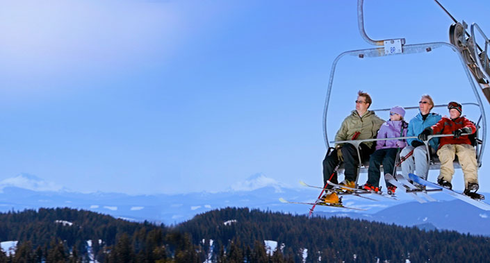 Family sitting together on a chair-lift at a Colorado Ski Resort.